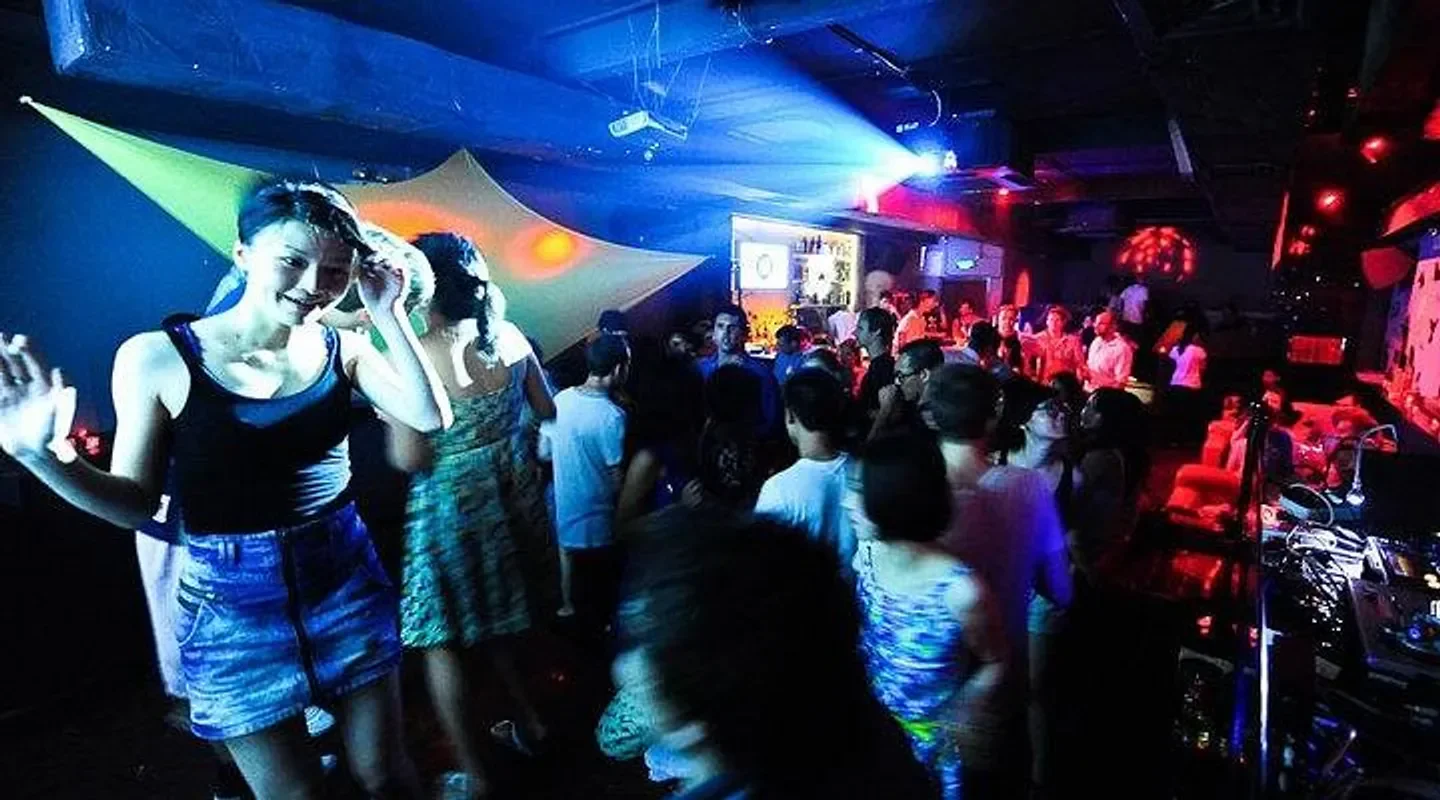 Energetic crowd enjoying the nightlife at Dada nightclub in Shanghai, colorful lights and dancing.