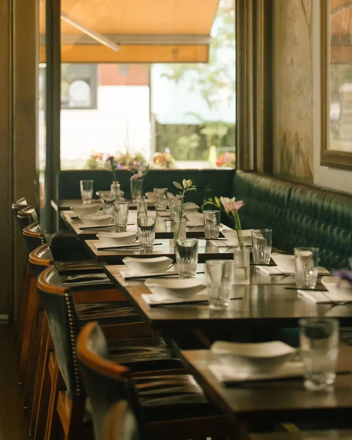 Dining space at DaiLo restaurant in Toronto, set tables with floral arrangements.