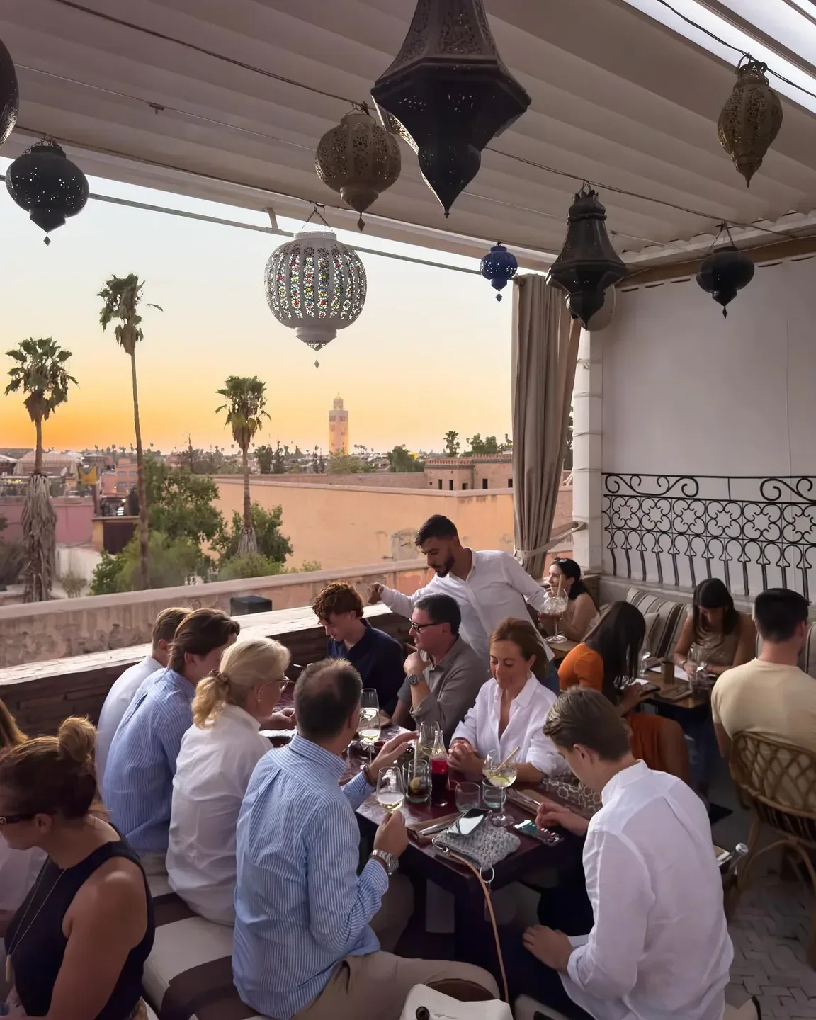 Dining at DarDar Rooftop in Marrakech, featuring city views and Moroccan lanterns.