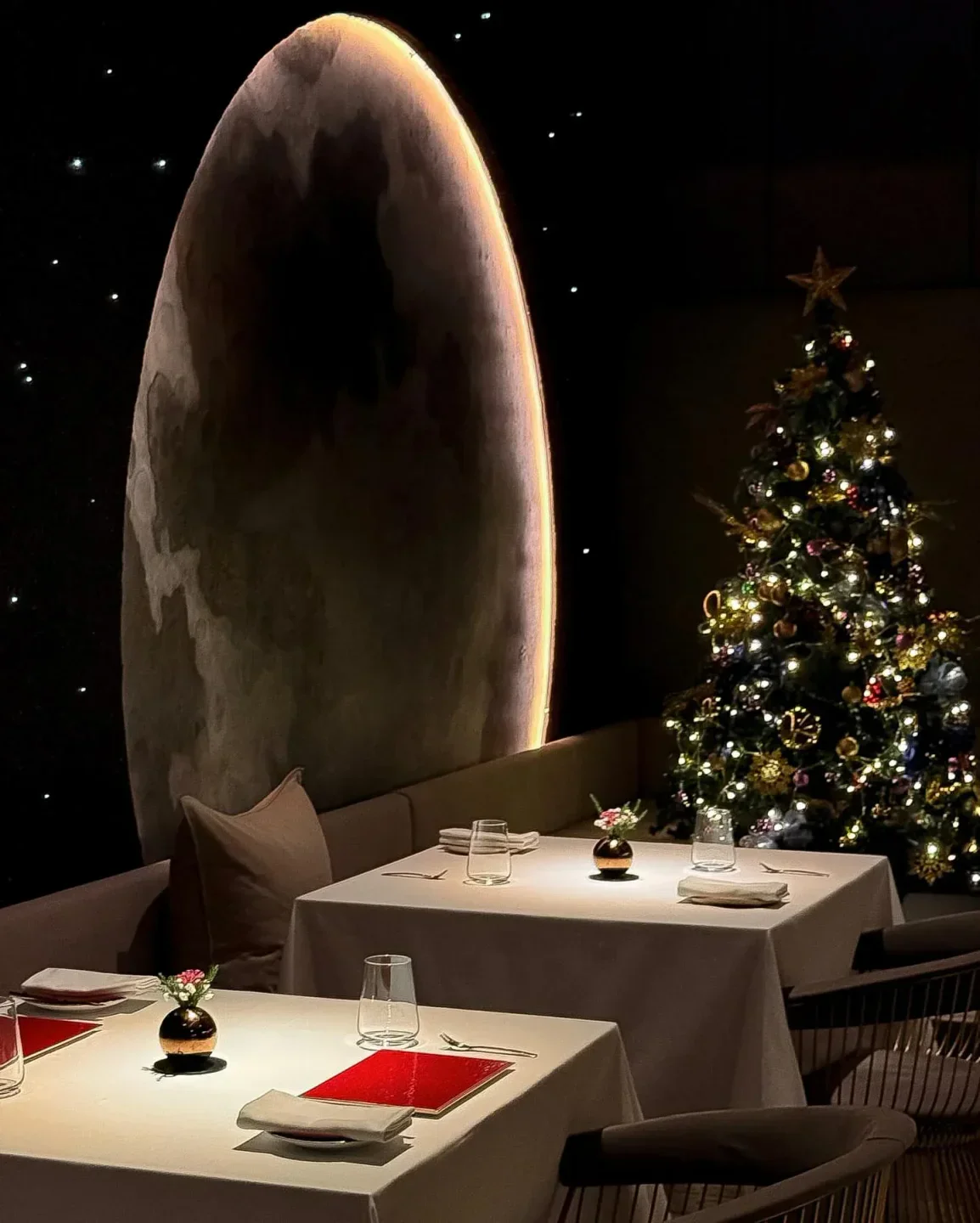 Cozy dining setting at DC. by Darren Chin in Kuala Lumpur, featuring a Christmas tree.