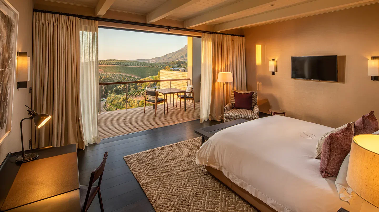 Luxury room at Delaire Graff Lodge in Cape Town, offering scenic balcony views.