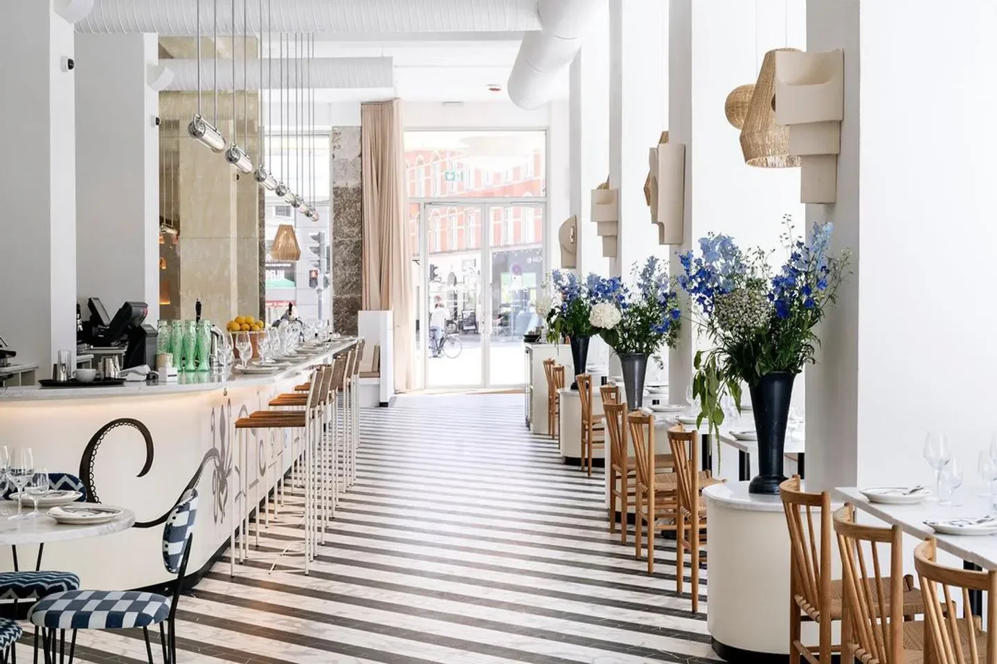 Stylish interior of Delphine restaurant in Copenhagen, with floral arrangements and striped floors.