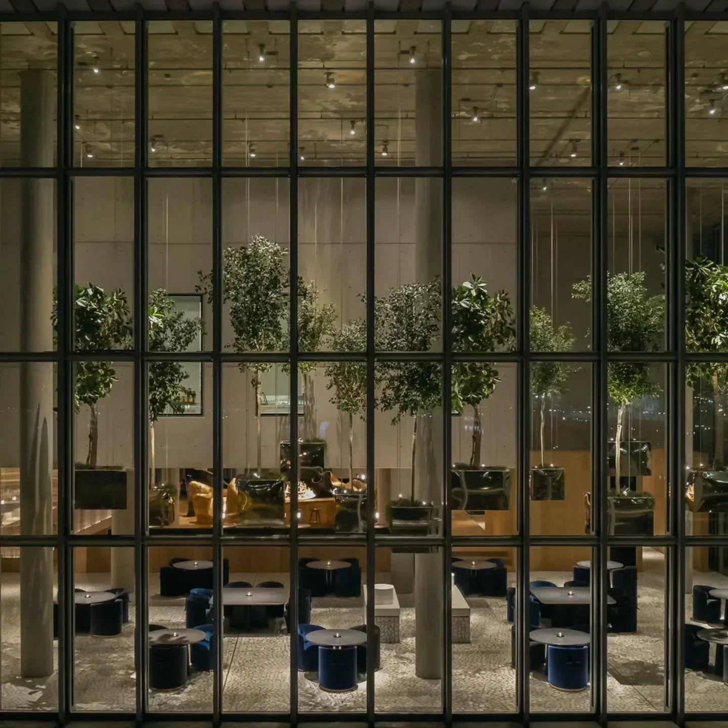 Modern interior of Delta Restaurant in Athens, featuring stylish decor and lush greenery.