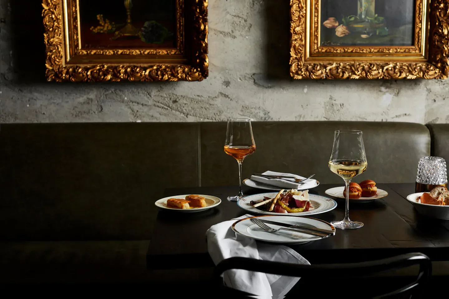 Dessous Melbourne: Fine dining table setting with wine glasses and gourmet dishes.