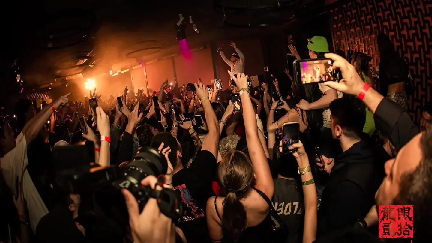 Energetic crowd at Dragon I nightclub in Hong Kong, capturing the moment with phones.