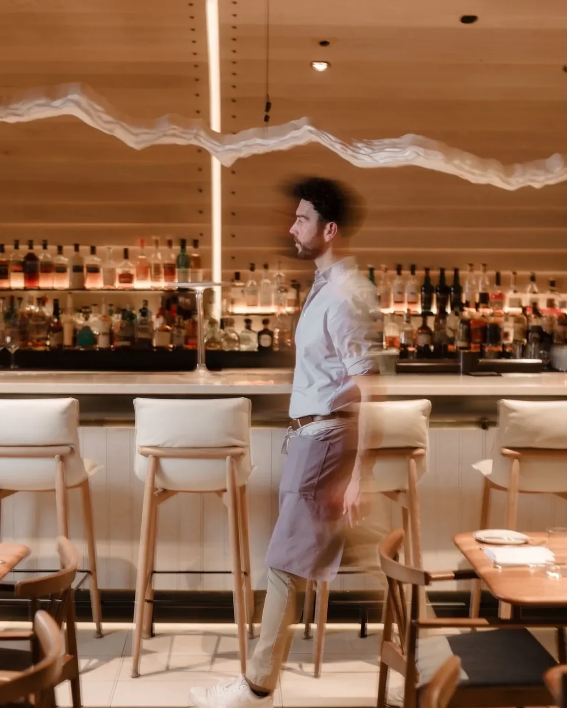 Interior of DRIFT restaurant in Halifax, with a blurred image of a staff member.