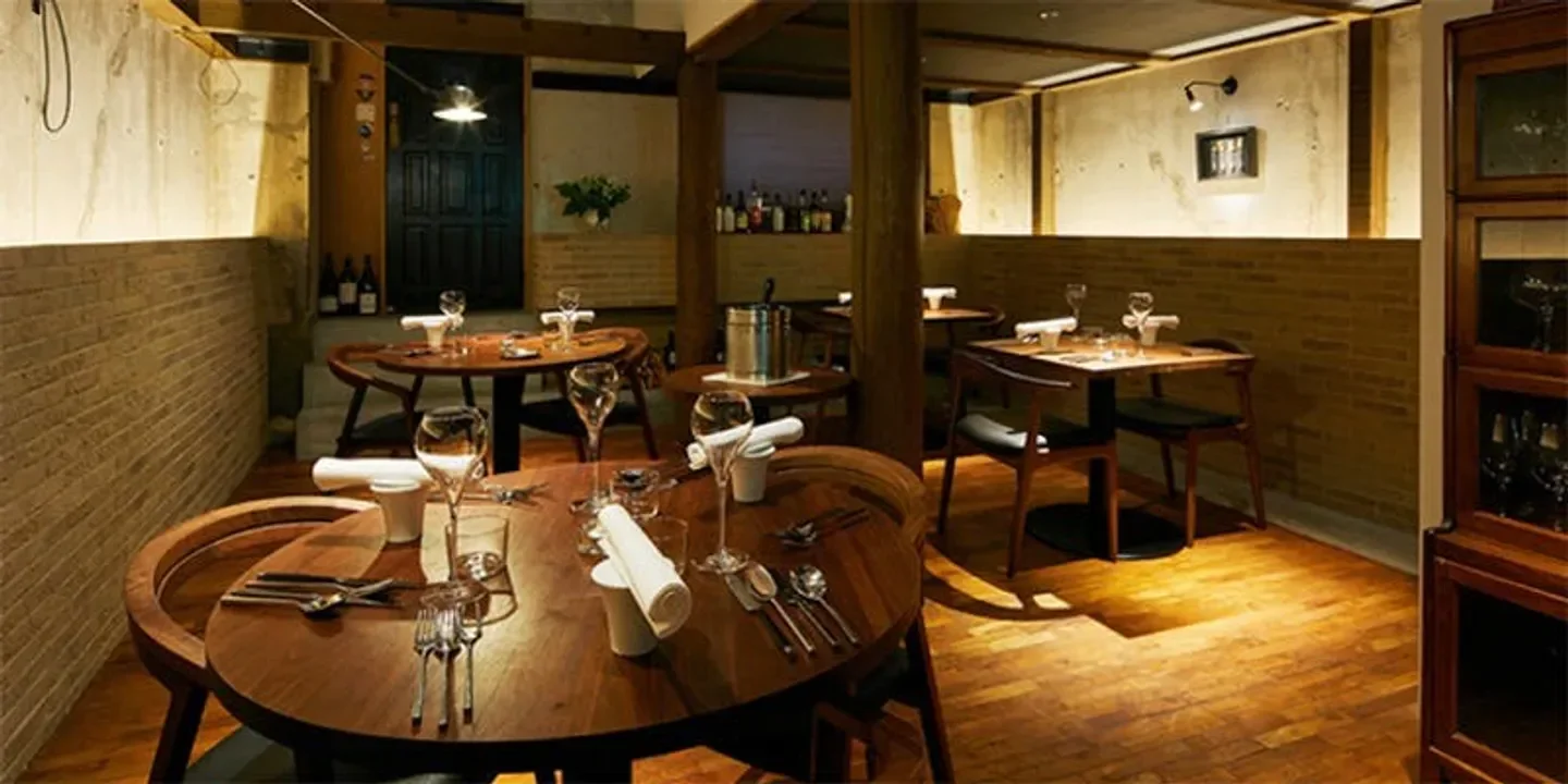 Cozy interior of Droit restaurant in Kyoto, with wooden tables and elegant setting.