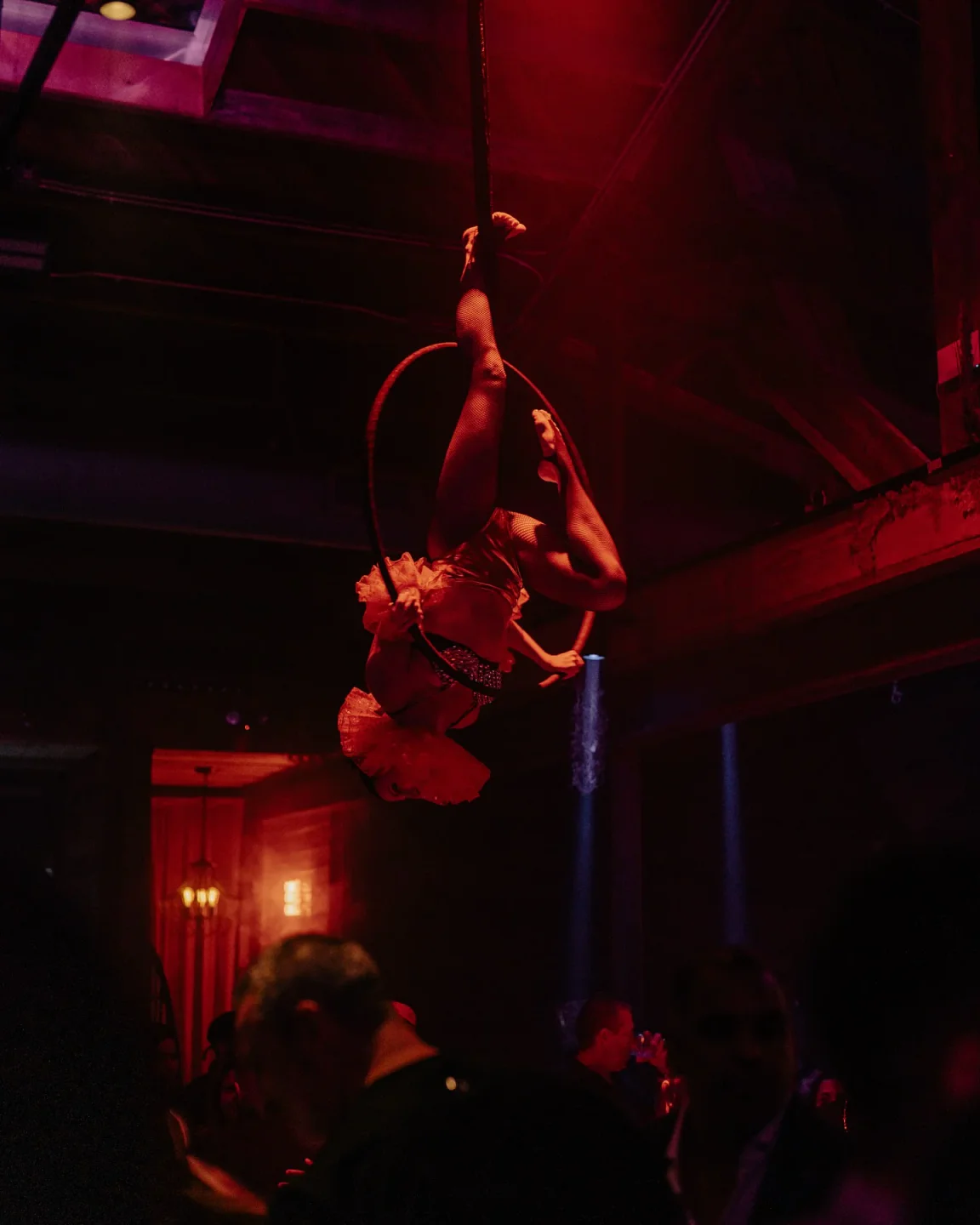 Aerial performer at El Santo Don Diablo nightclub in Miami. Nightlife ambiance with a captivating show and dim lighting.