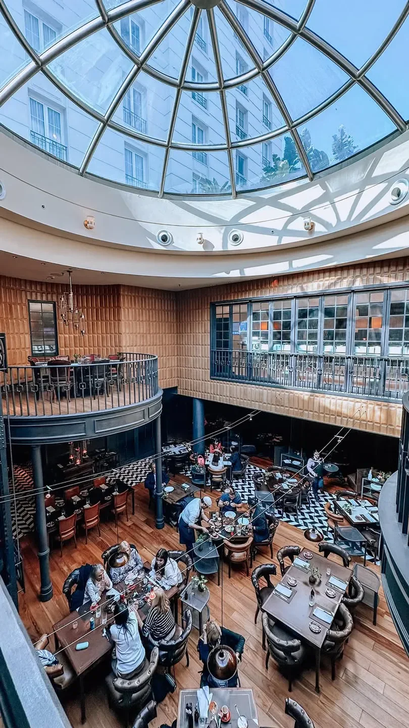 Elegant dining at Elena in Buenos Aires, under a stunning glass dome ceiling.