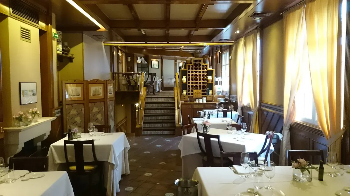 Interior dining space at Elkano restaurant in San Sebastian, tables set for service.