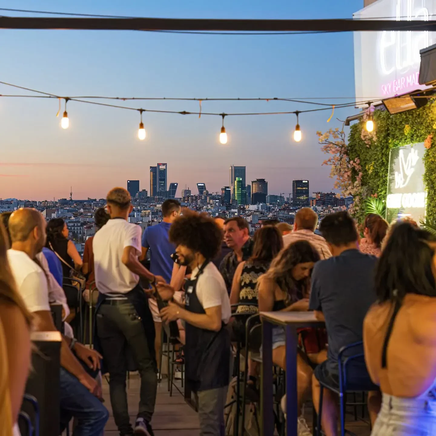 Ella Sky Bar in Madrid rooftop at dusk with city views and people dining.