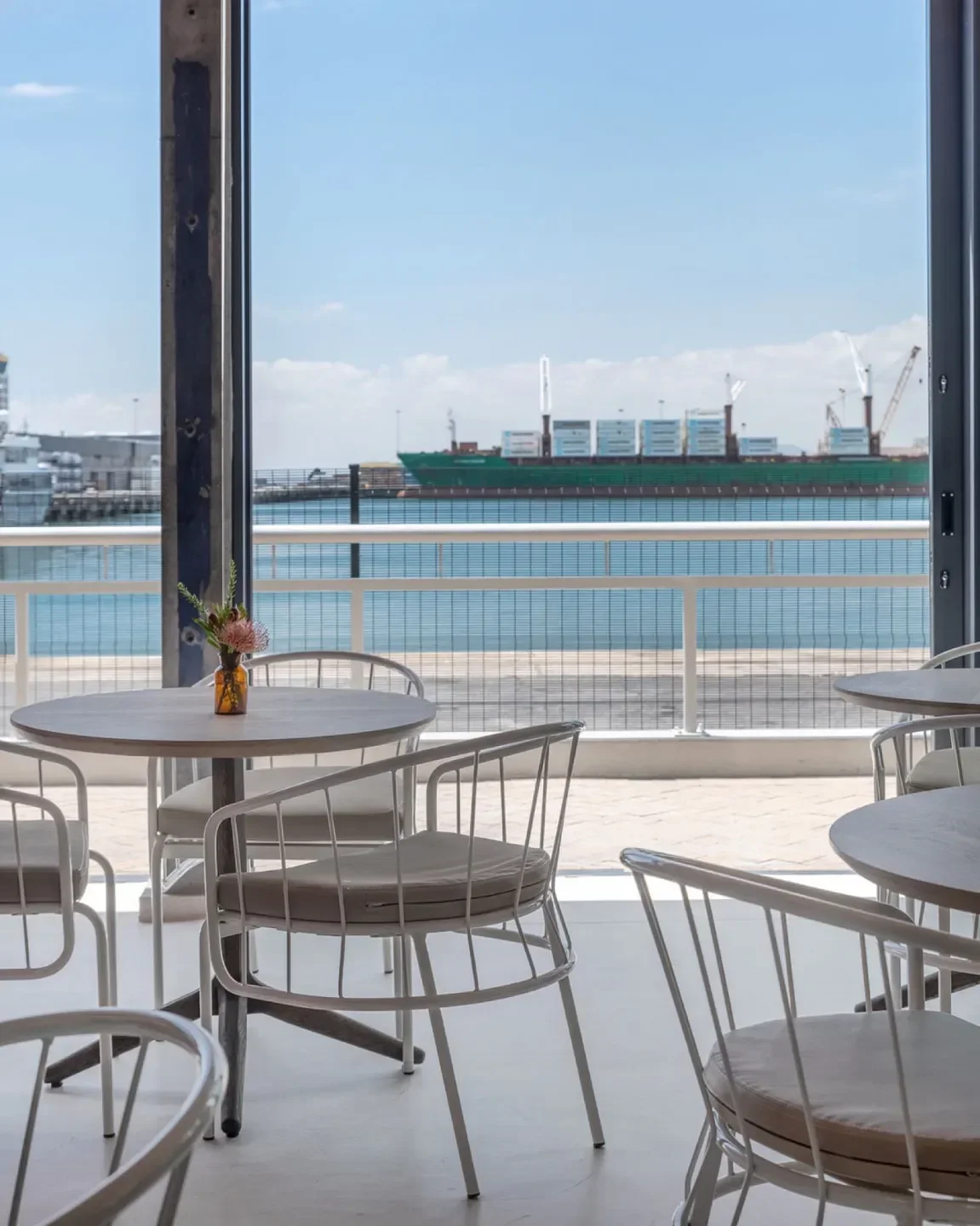Emazulwini Restaurant in Cape Town: stylish dining area with harbor view and flower detail