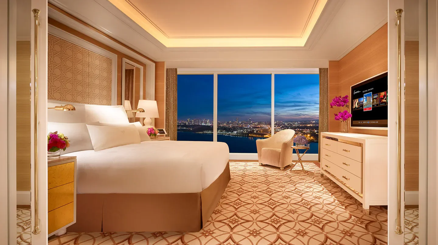Luxury hotel room at Encore Boston Harbor with city views of Boston at dusk.