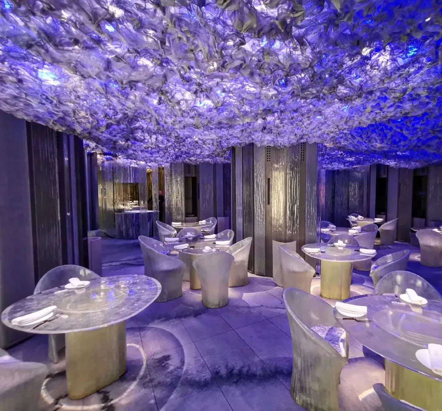 Unique dining room interior at Enigma restaurant in Barcelona, with artistic ceiling and decor.
