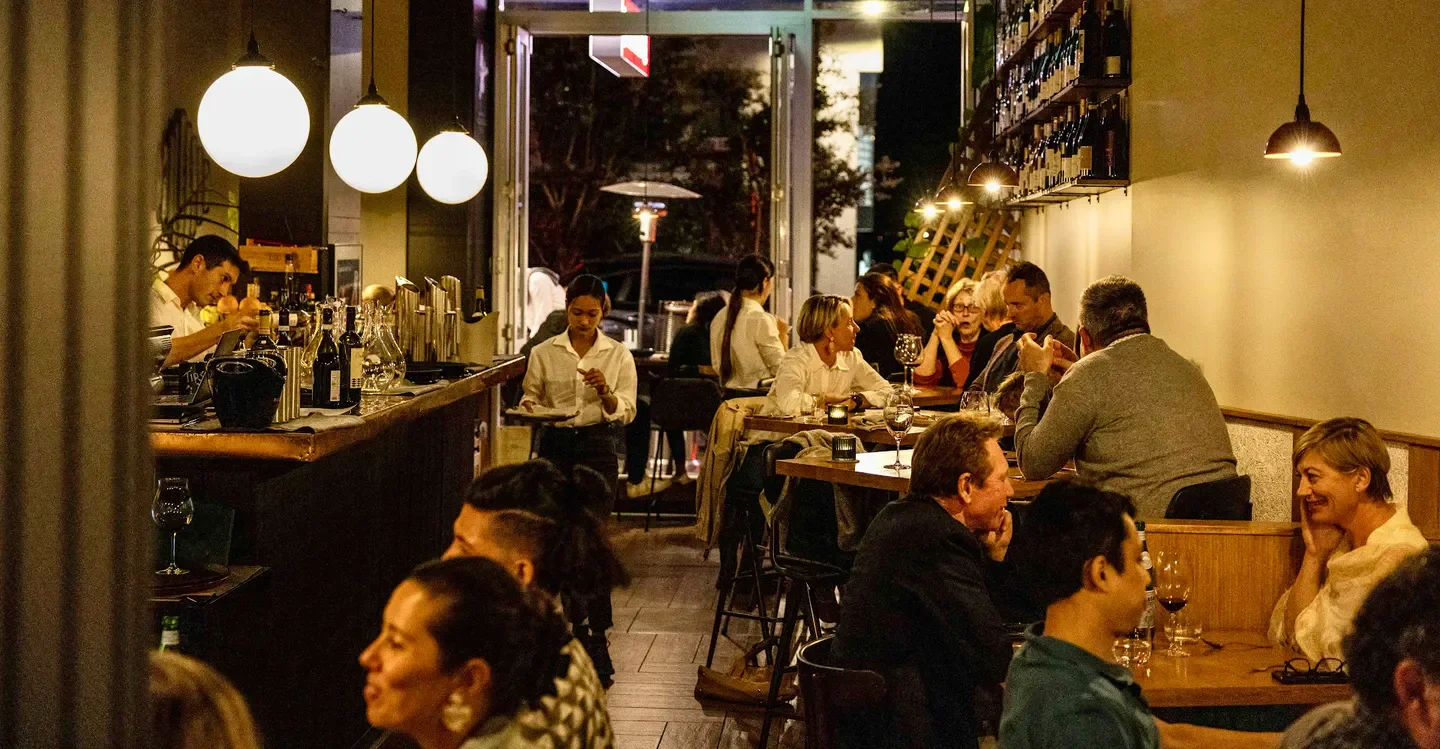 Cozy dining room at Enoteca Ponti in Sydney, with patrons enjoying dinner and drinks.