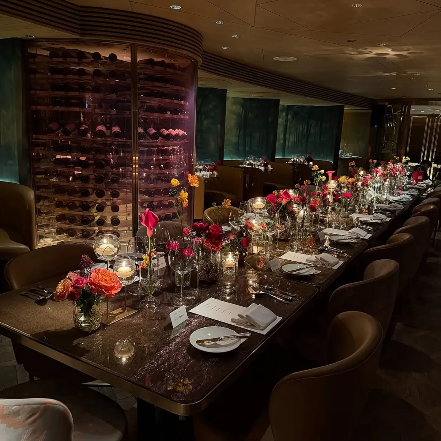 Elegant dinner setting at Épure restaurant in Hong Kong, featuring flowers and wine display.