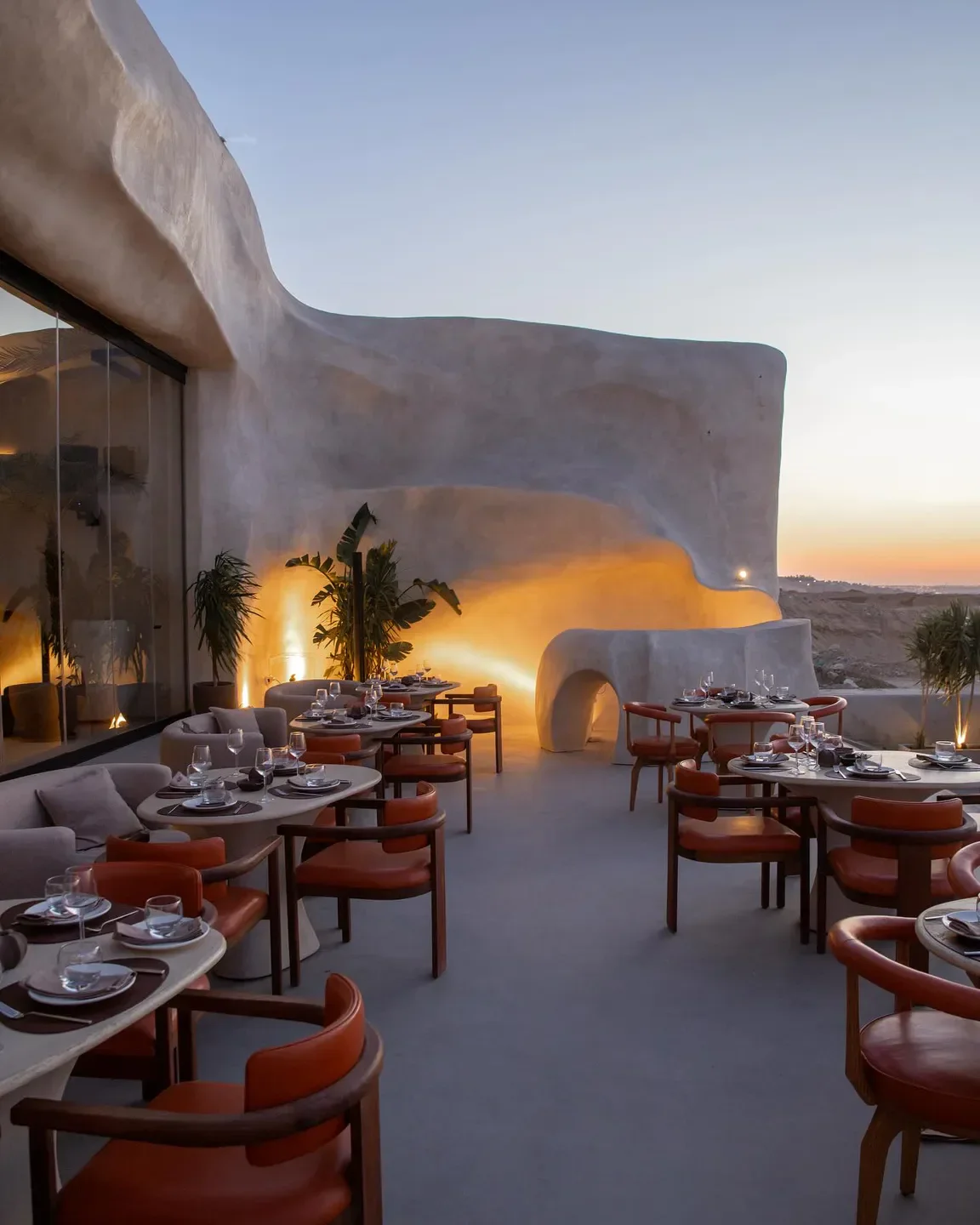 Outdoor dining at ESCĀ CUEVA in Cairo, Egypt, with sunset views and modern architecture.