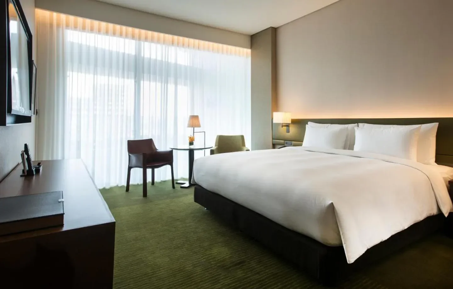 Elegant hotel room at Eslite Hotel in Taipei, featuring a comfortable bed and natural light.