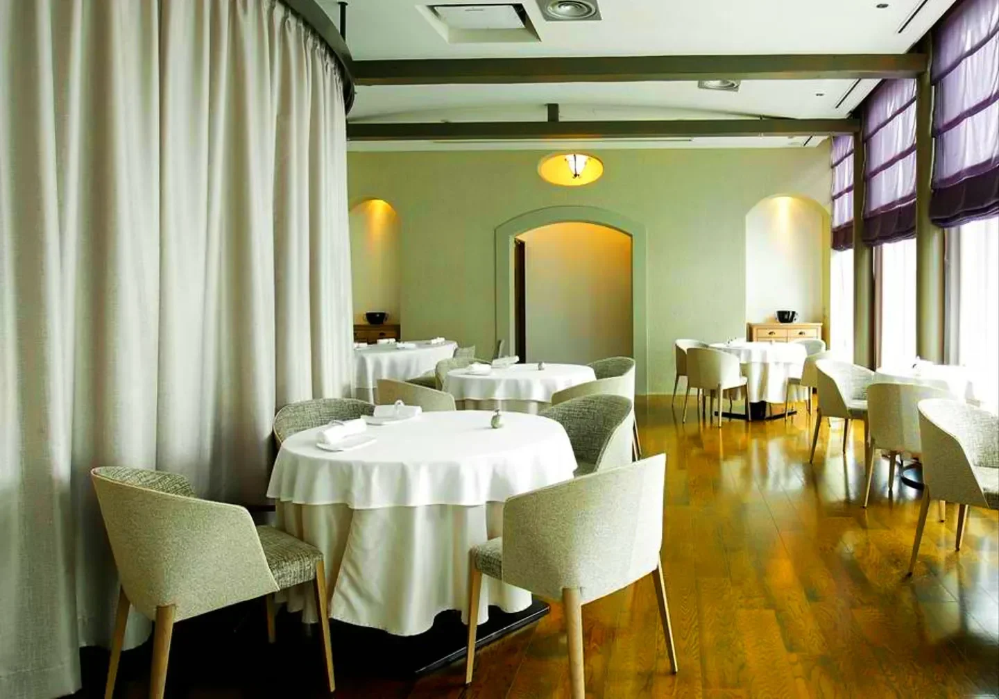 Elegant dining room interior at Esquisse restaurant in Tokyo with round tables and chairs.
