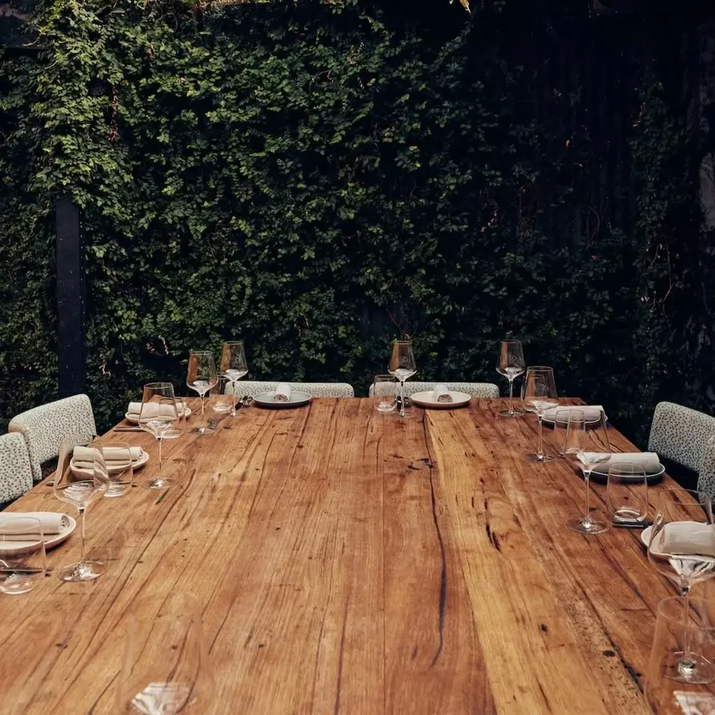 Etta restaurant in Melbourne, wooden table set for dinner with glasses and elegant decor