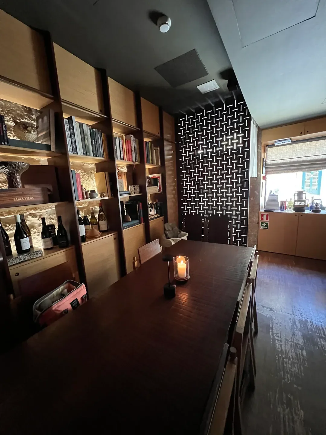 Cozy dining area at Euskalduna Studio in Porto with a lit candle and bookshelves.