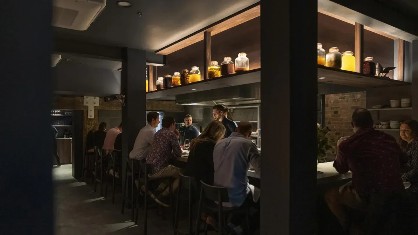 Interior of Exhibition restaurant in Brisbane, showcasing the bar and patrons.