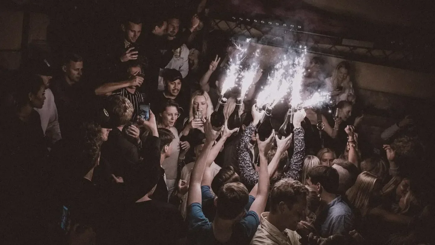 Party at F12 Terrassen nightclub in Stockholm with sparklers and raised bottles