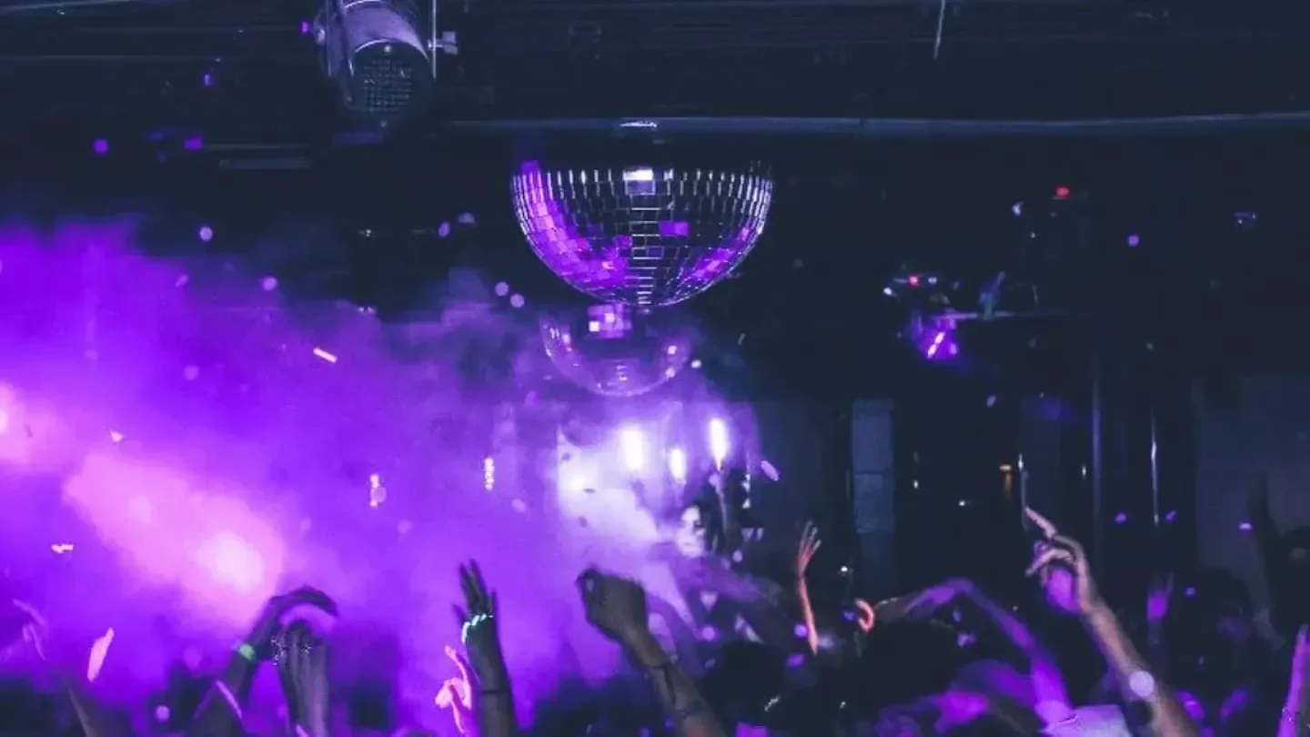 Disco ball and crowd at F6ix nightclub in San Diego with purple lights.