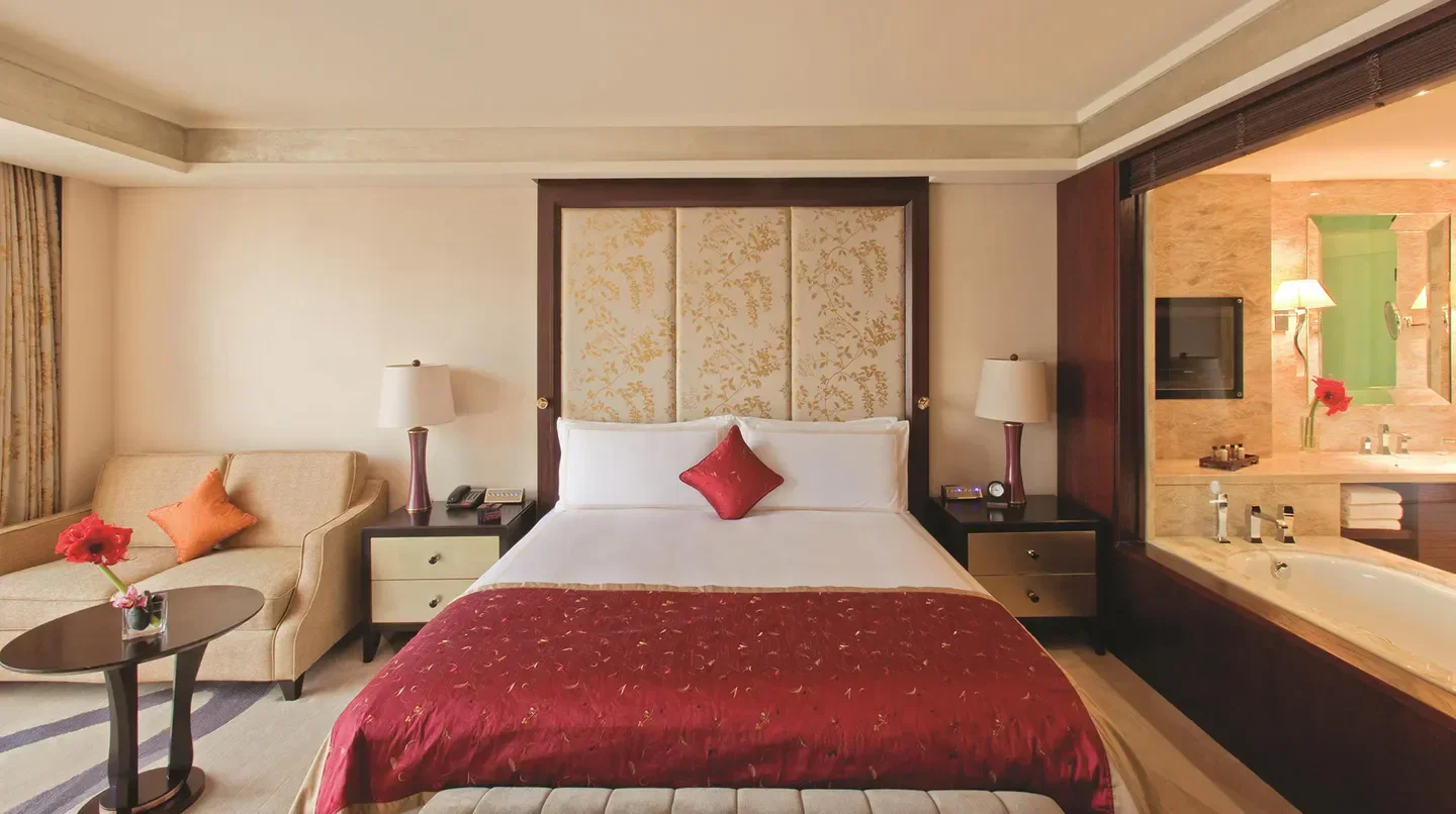 Cozy bedroom at the Fairmont Beijing Hotel, featuring a comfortable bed and relaxing atmosphere in Beijing.