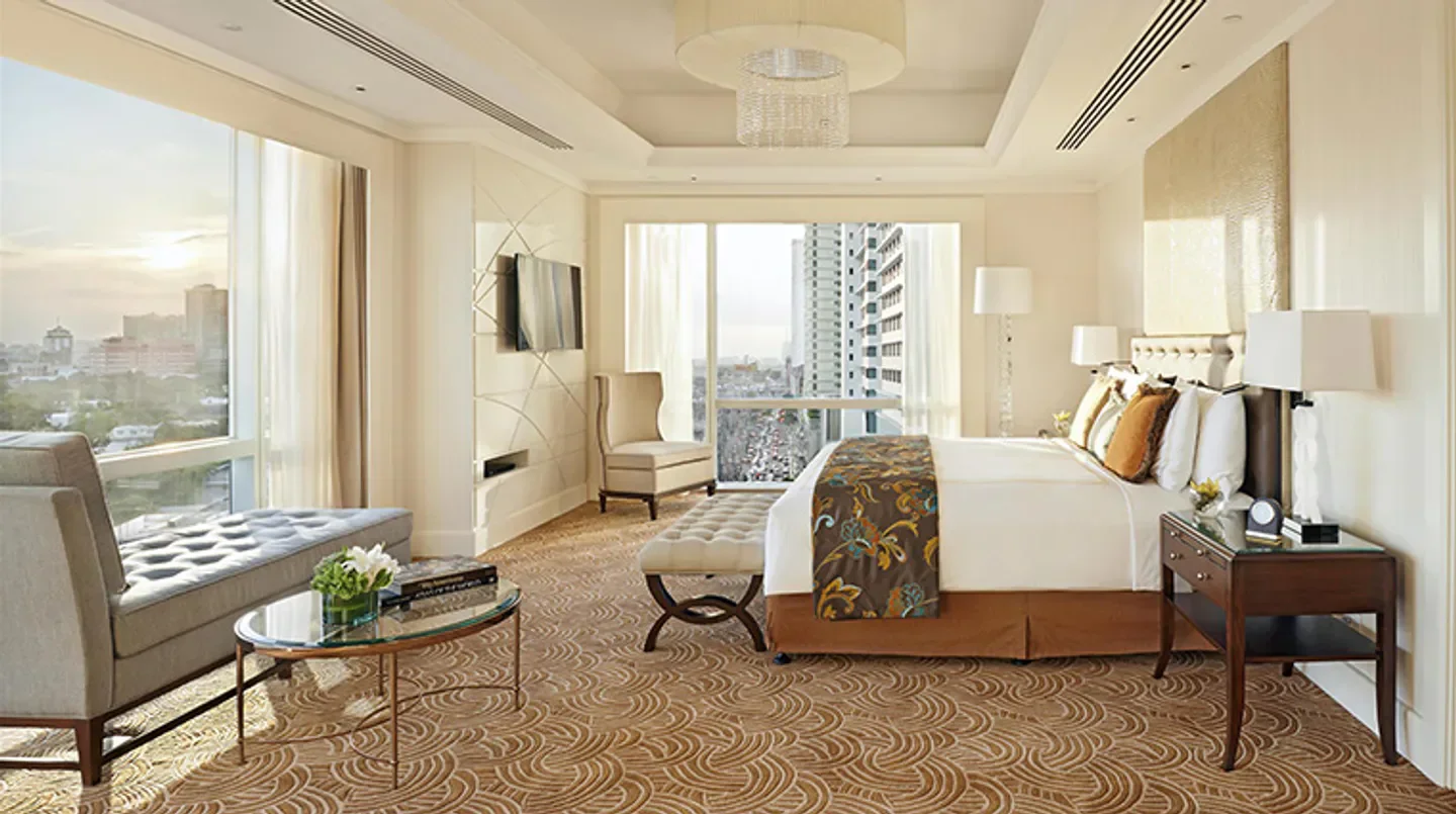 Luxury hotel room at Fairmont Makati with views of Manila city skyline.