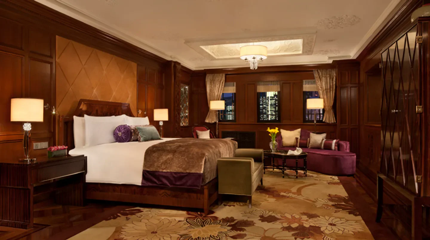 Luxury bedroom at Fairmont Peace Hotel in Shanghai with city views at night.