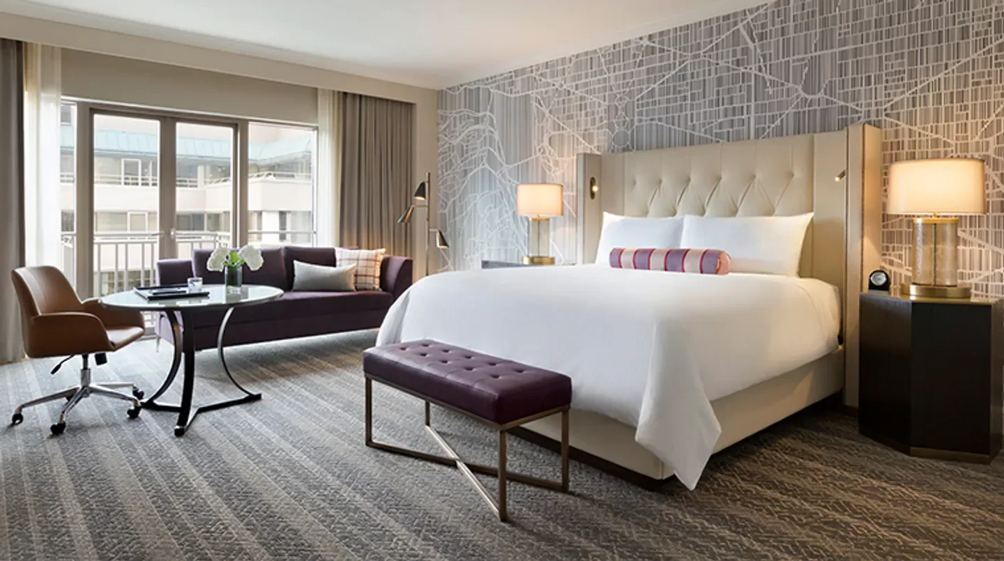 Elegant bedroom at Fairmont Washington, D.C., Georgetown, featuring a map-themed wall in Washington.
