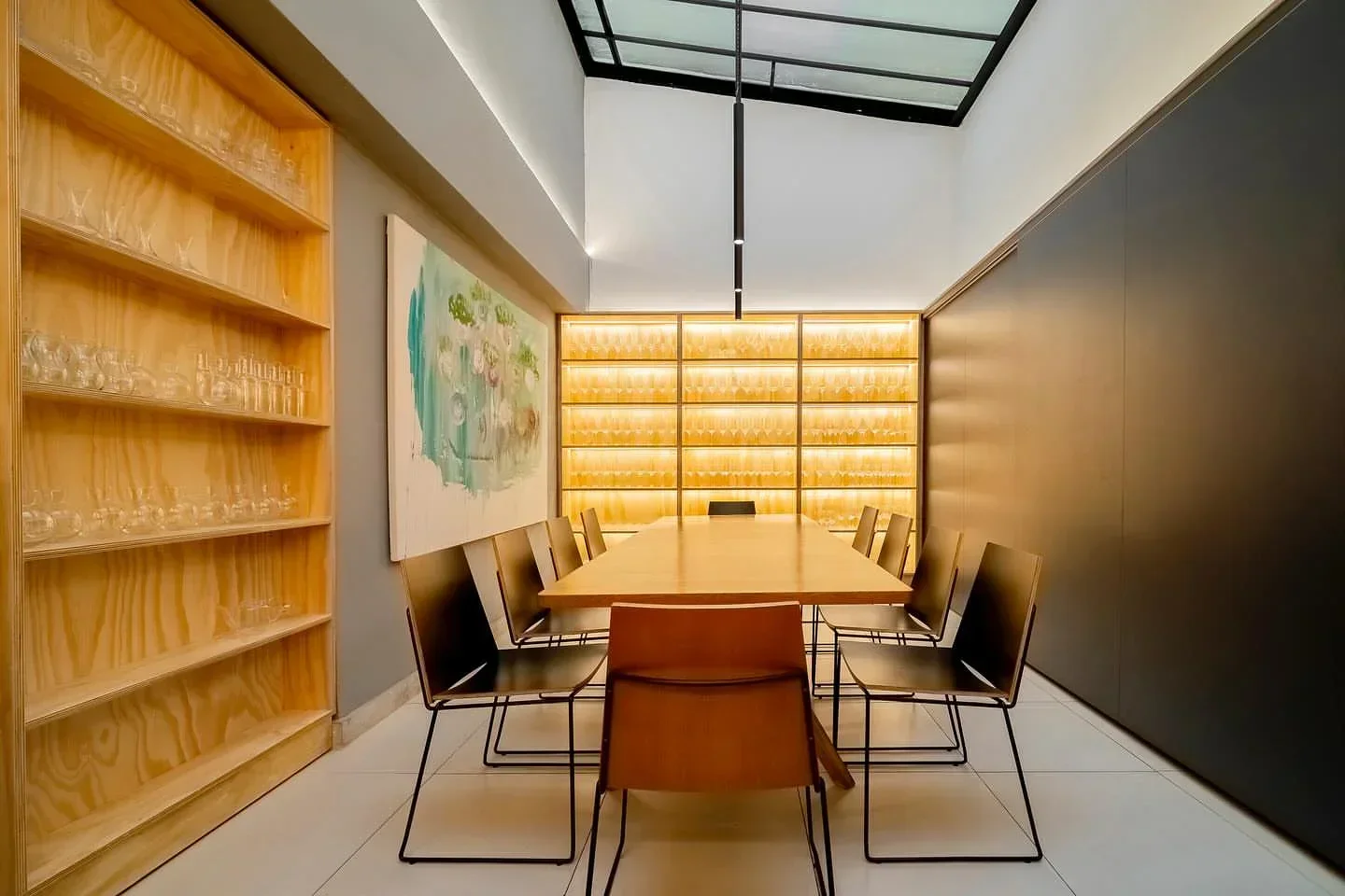Interior dining space at Fame Osteria in Sao Paulo, featuring wooden shelves and art.