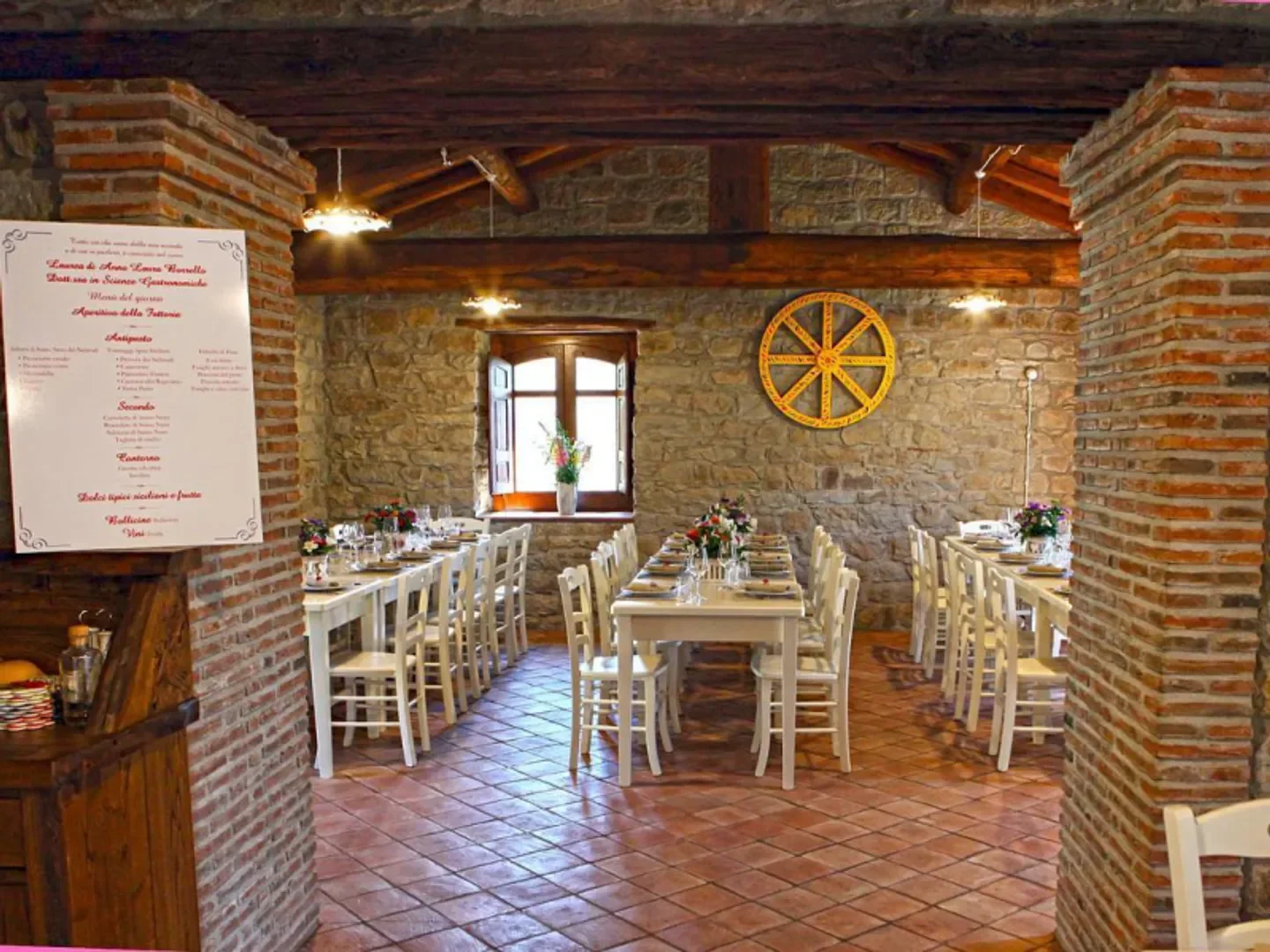 Interior dining space at Fattoria Borrello restaurant in Sicily, with tables set and ready.