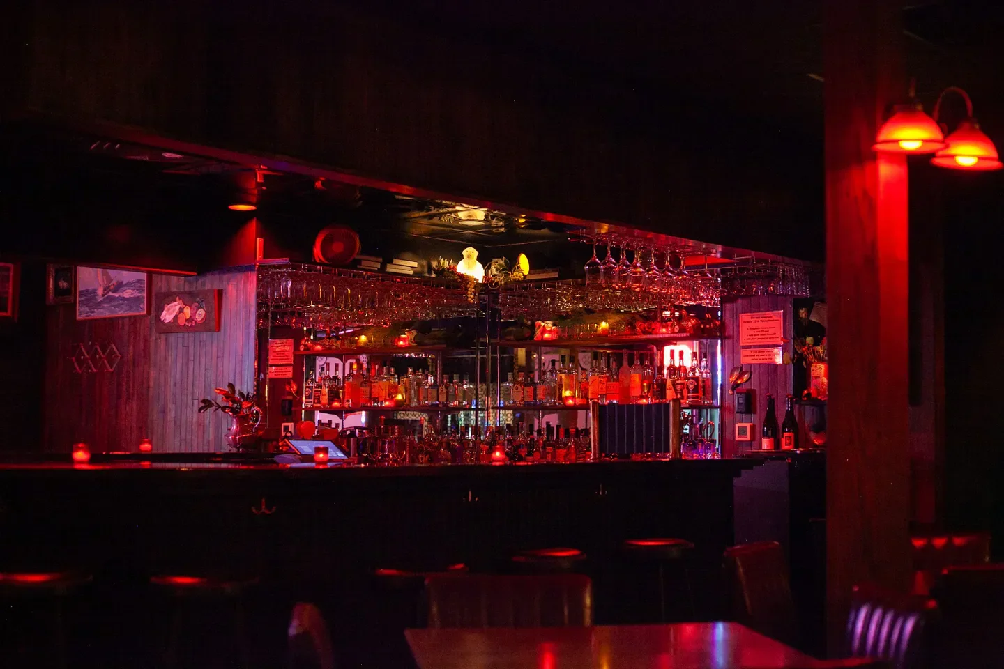 Fet-Fisk restaurant in Pittsburgh bar scene with red lighting, bottles, and glasses.