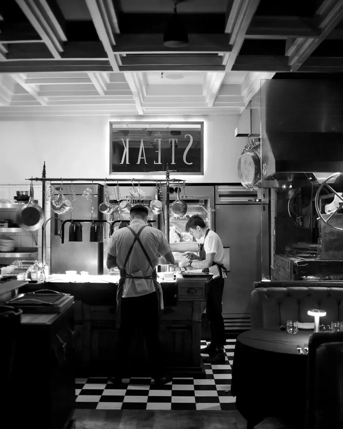 Chefs preparing food at Fia Steak in Los Angeles, captured in black and white.