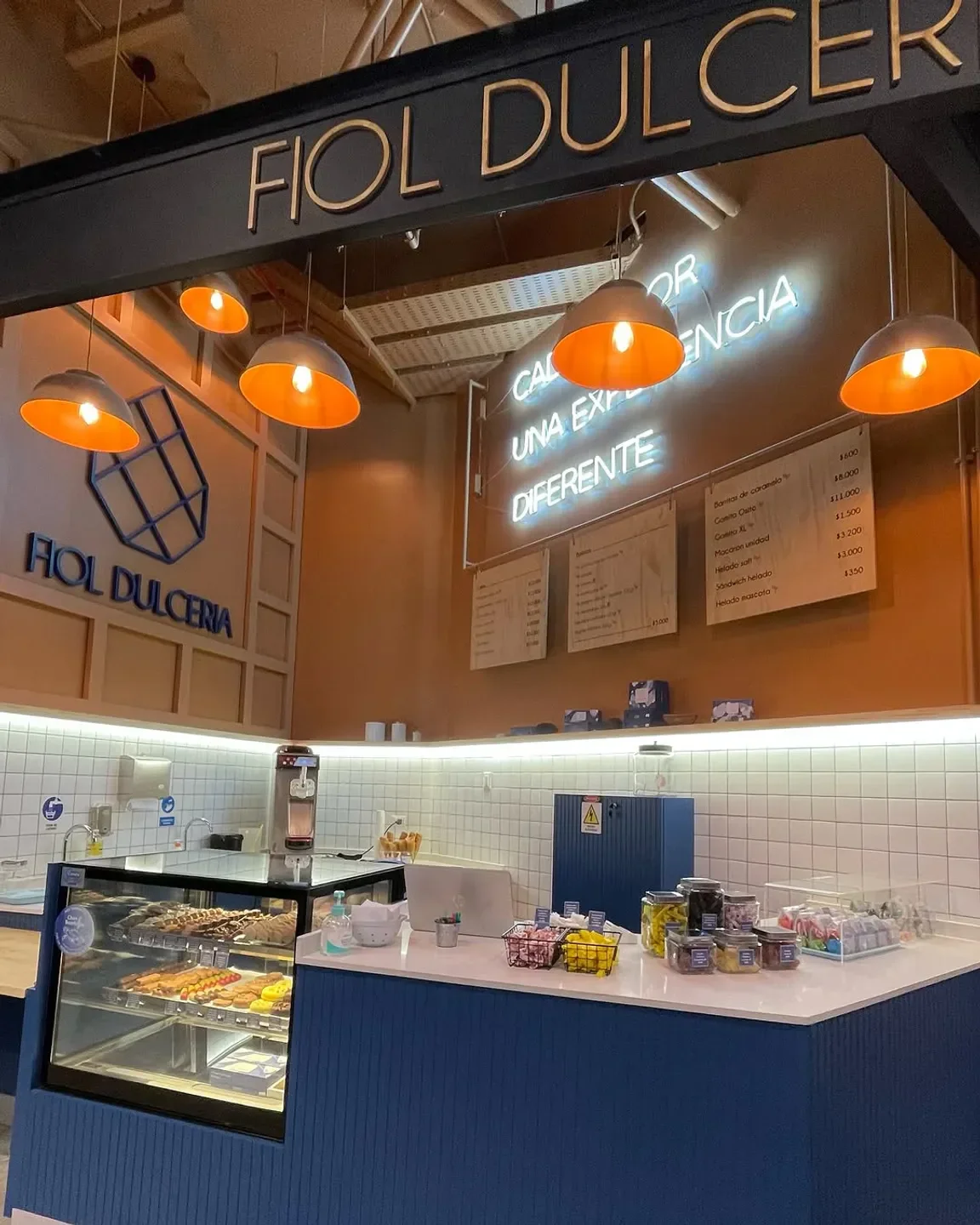 Interior of Fiol Dulceria in Santiago, featuring bright lights, counter with sweets and menu