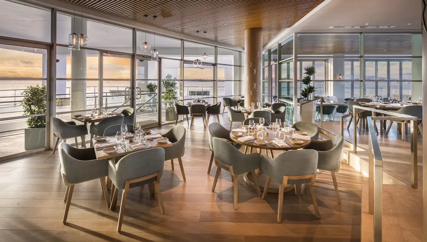 Interior of FISH Restaurant in Auckland, showing dining tables and beautiful waterfront views