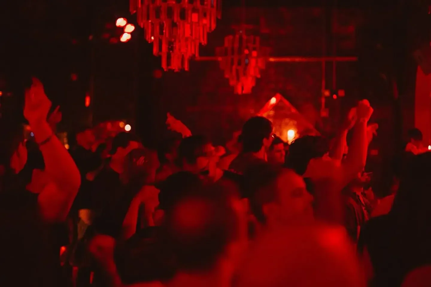 Energetic crowd at Floyd Miami nightclub dancing under red lights.