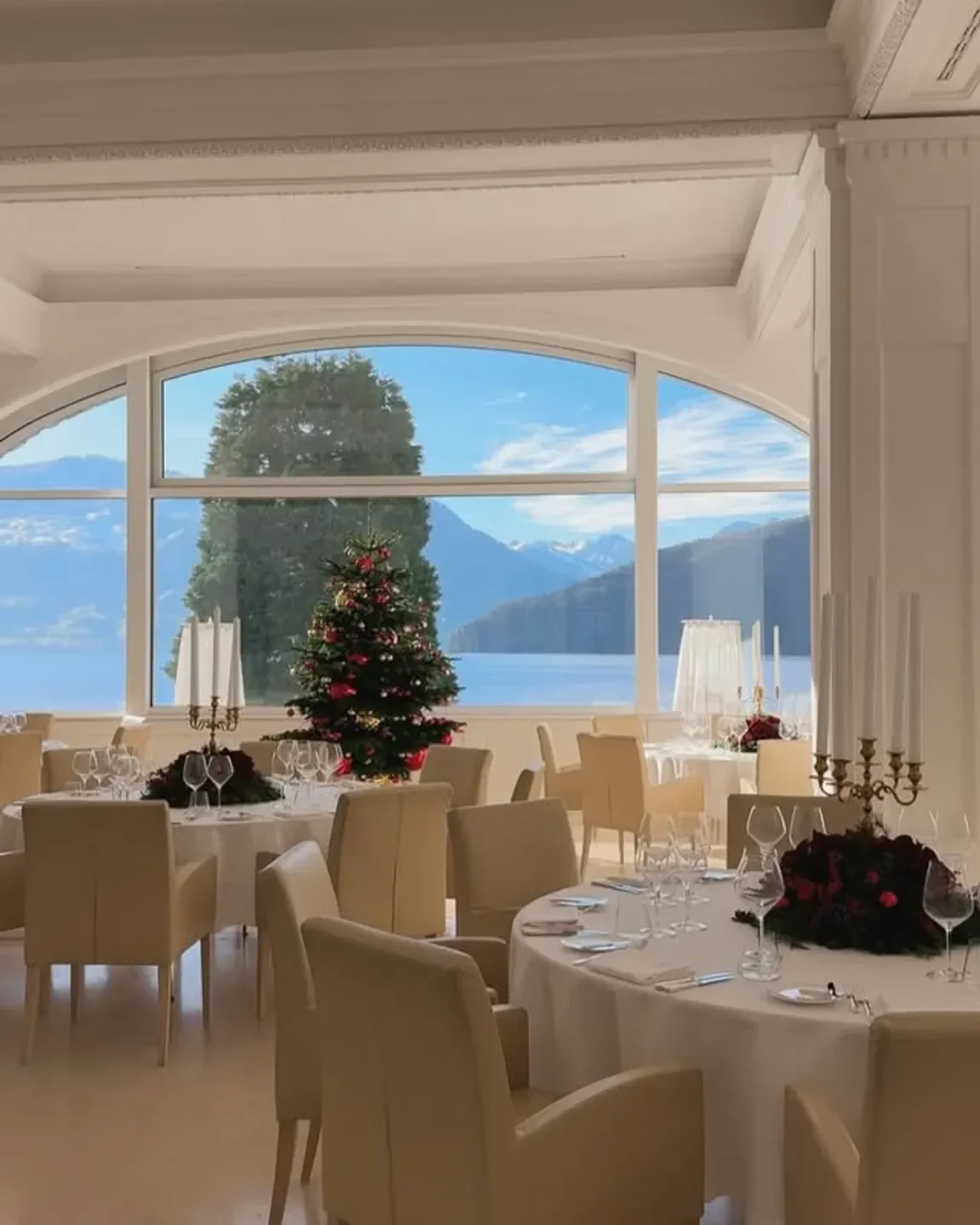 Elegant dining room at focus ATELIER in Lucerne with Christmas tree and lake view.