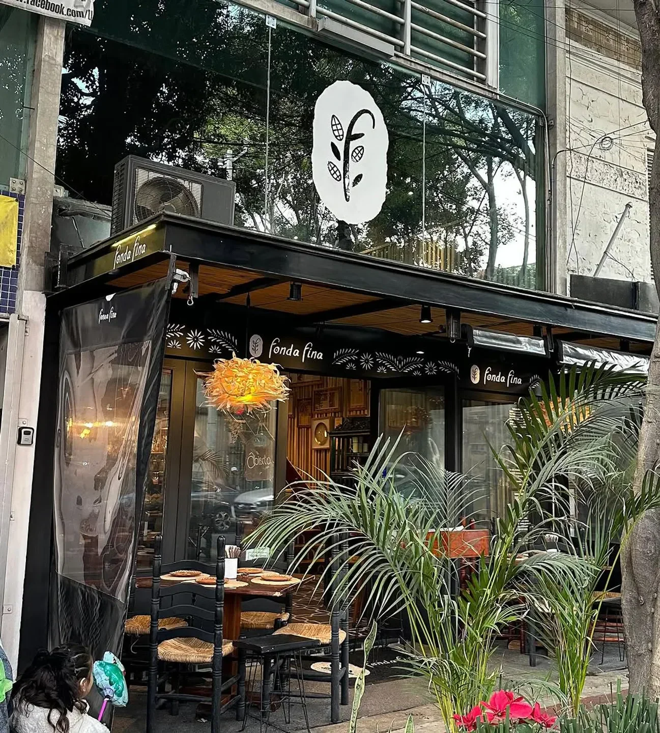 Exterior of Fonda Fina restaurant in Mexico City with outdoor seating and lush plants