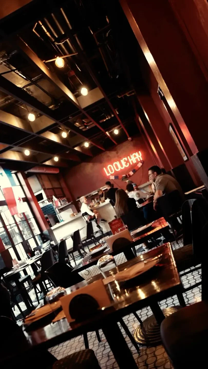 Interior of Fonda Lo Que Hay restaurant in Panama City, with diners and neon sign.