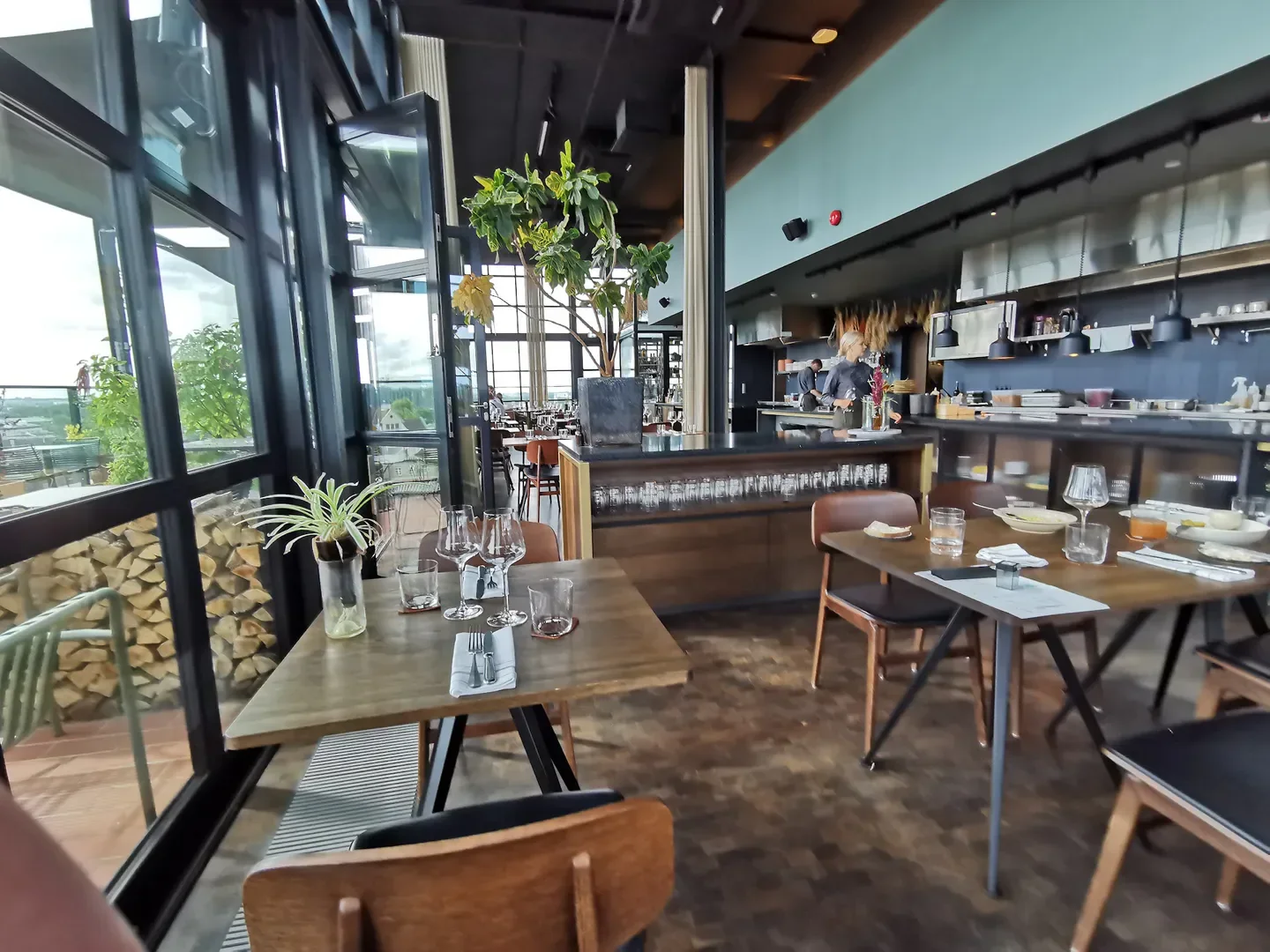 Interior dining at Fotografiska restaurant in Tallinn with open kitchen and city views