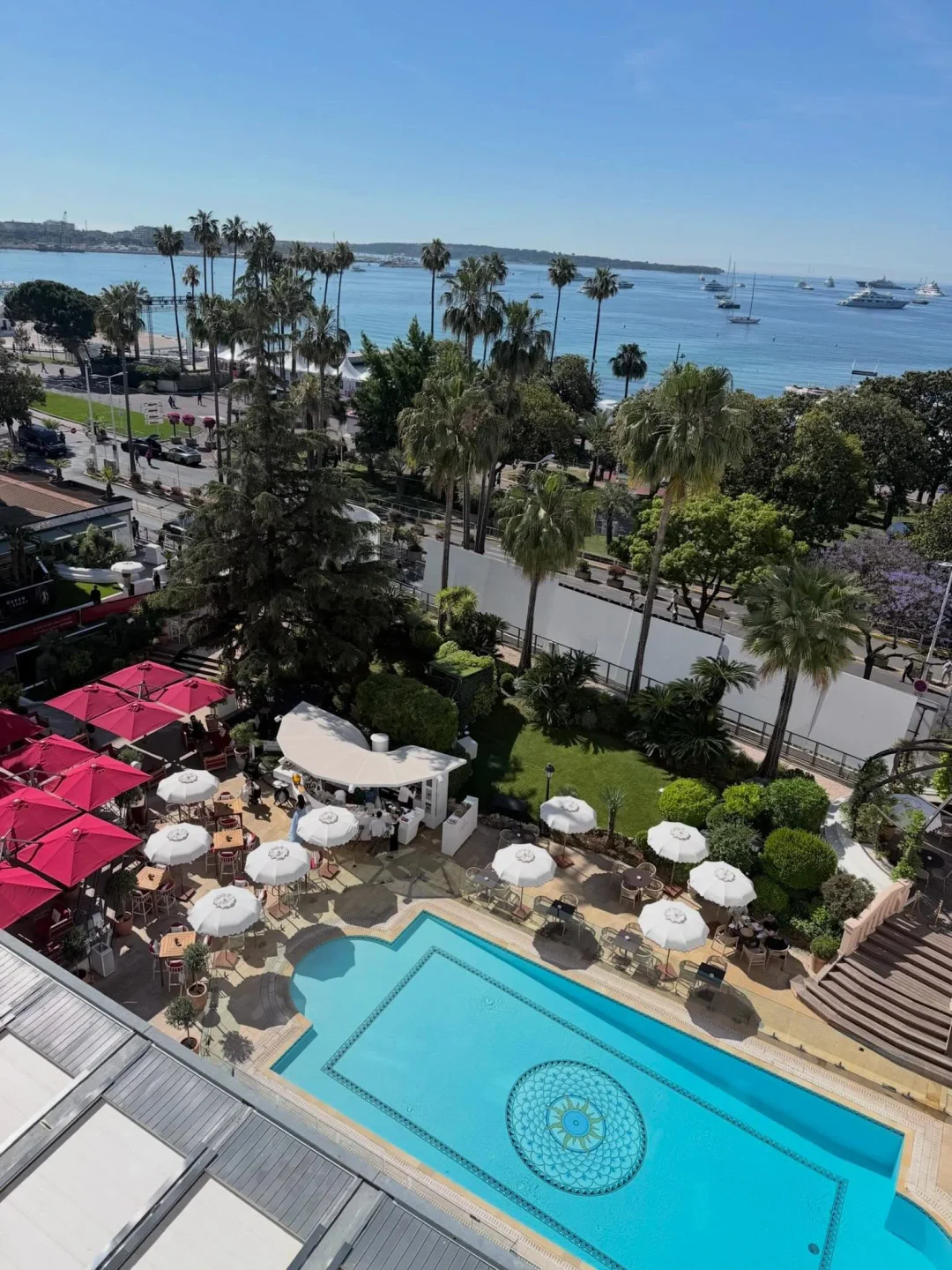Fouquet's Cannes boasts a stunning poolside terrace with red umbrellas and views of yachts in the bay.