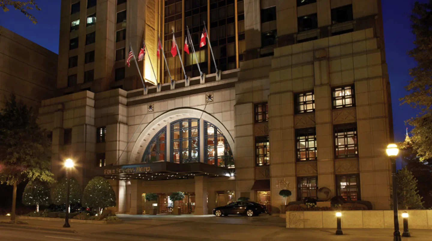 Four Seasons Hotel Atlanta entrance at night in Atlanta, with flags and lights.