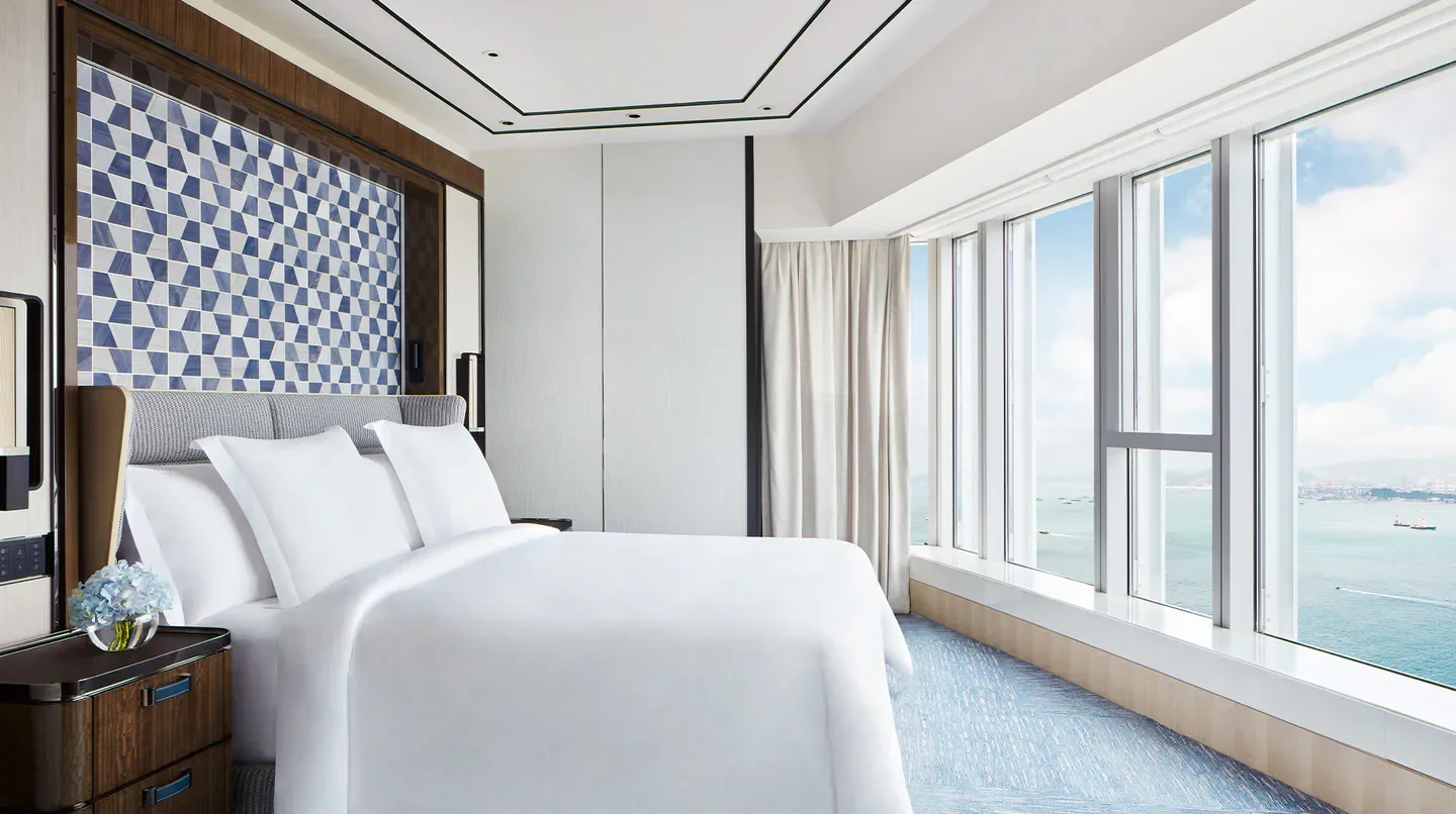 Luxury bedroom at Four Seasons Hotel Hong Kong with stunning city and sea views
