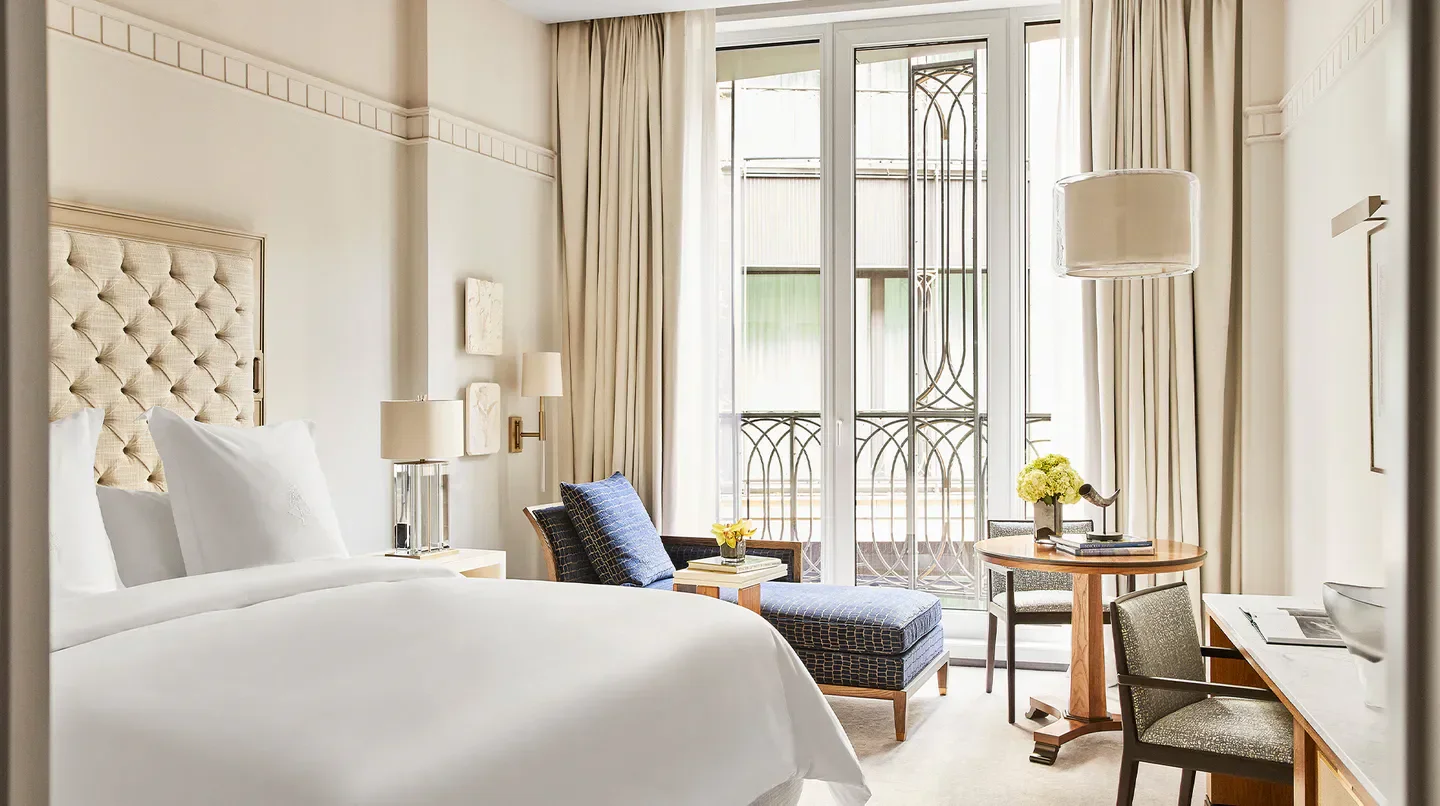 Elegant bedroom at Four Seasons Hotel Madrid, featuring cozy seating and natural light in Madrid.