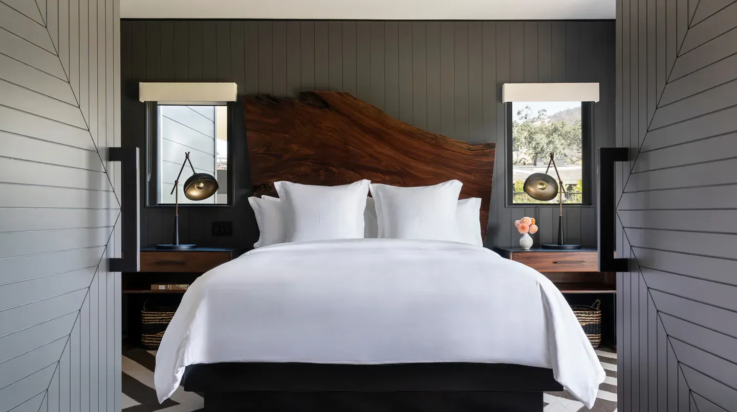 Cozy bedroom at Four Seasons Resort and Residences Napa Valley, with wooden headboard detail.