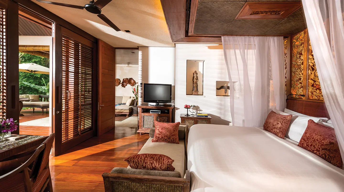 Luxury bedroom at Four Seasons Resort Bali at Sayan with wooden decor and views.