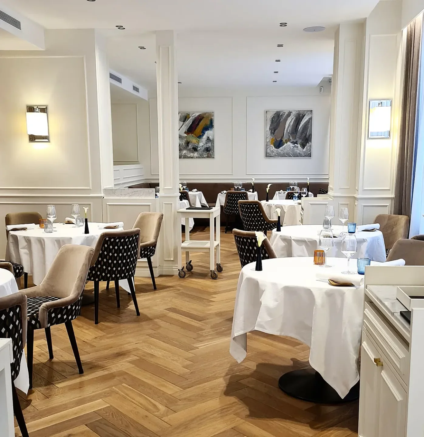 Elegant dining room at Frédéric Simonin restaurant in Paris with art and tables.